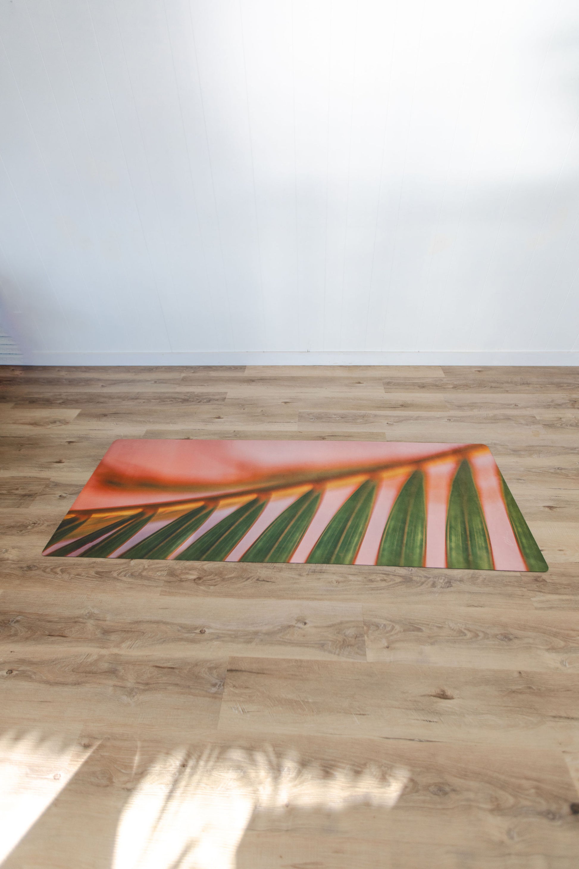 Yoga mat with leaf design on a wooden floor