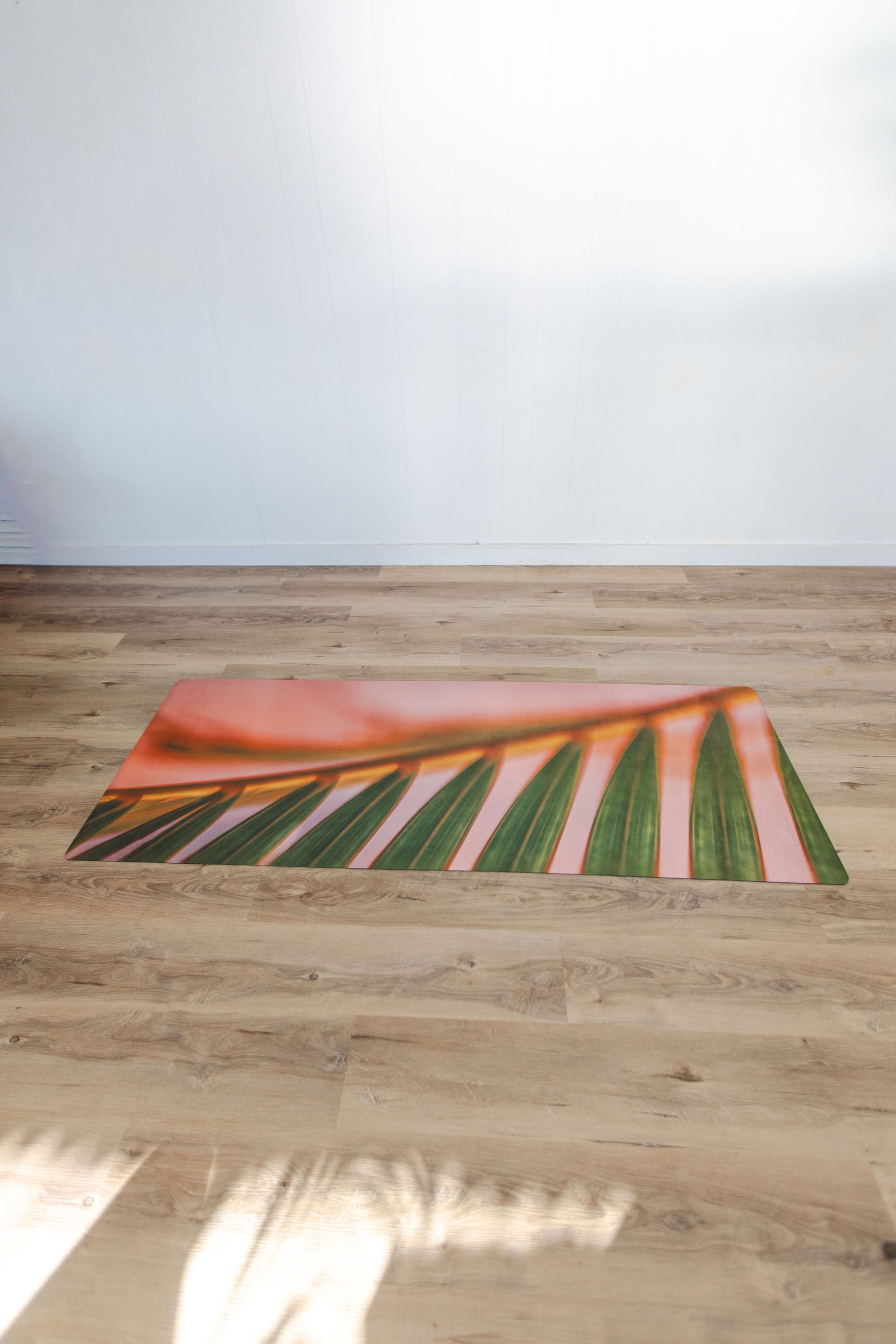 Yoga mat with leaf design on a wooden floor