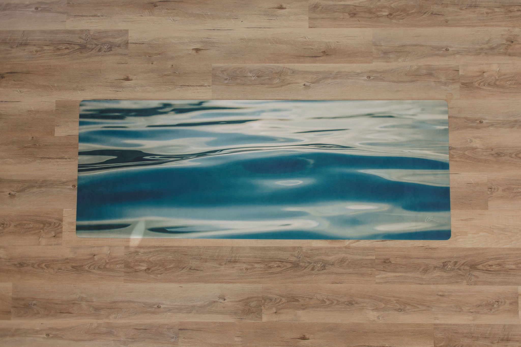 Yoga mat with blue abstract design on a wooden floor