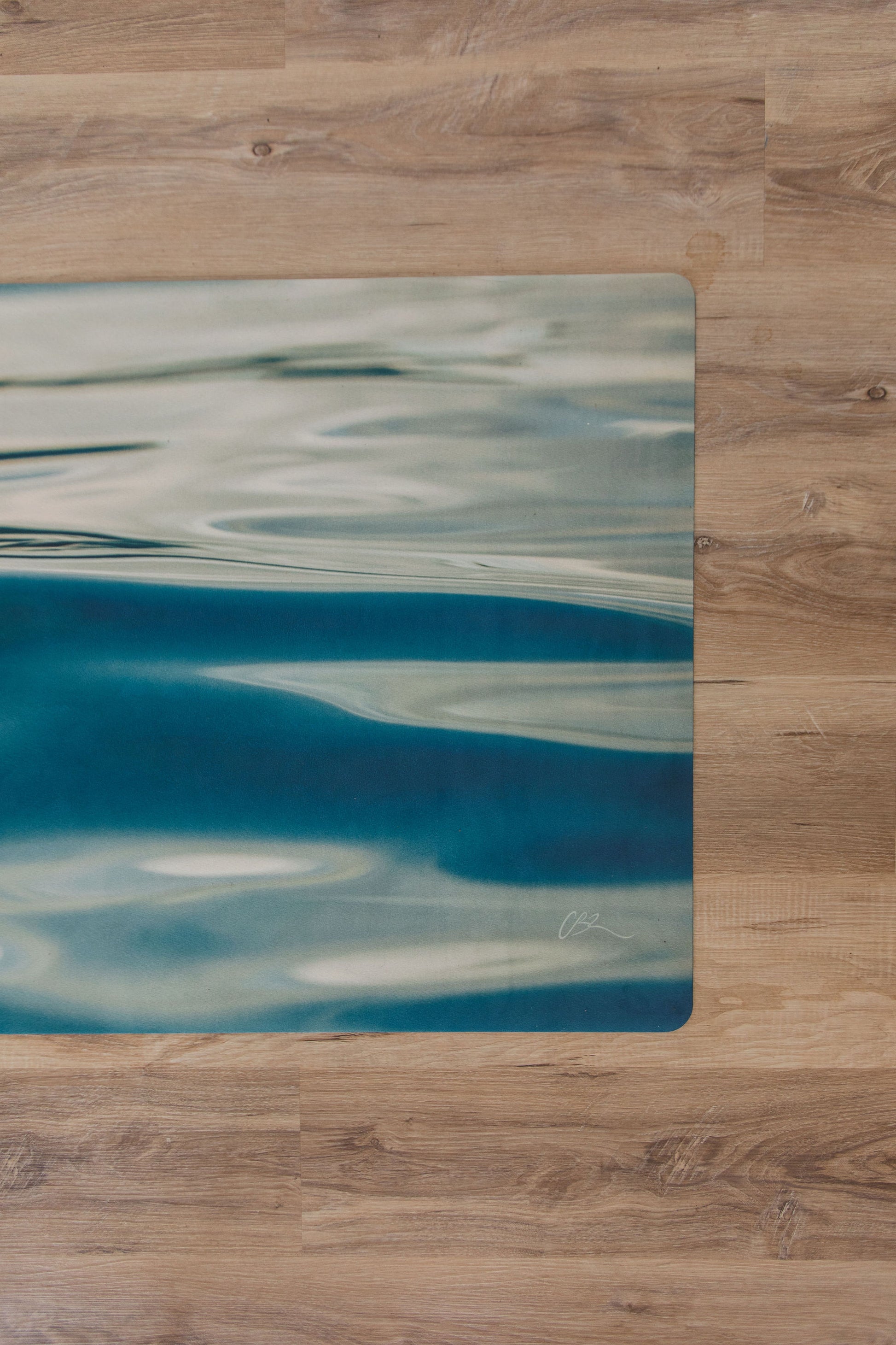 Abstract blue and white design workout fitness mat on a wooden surface