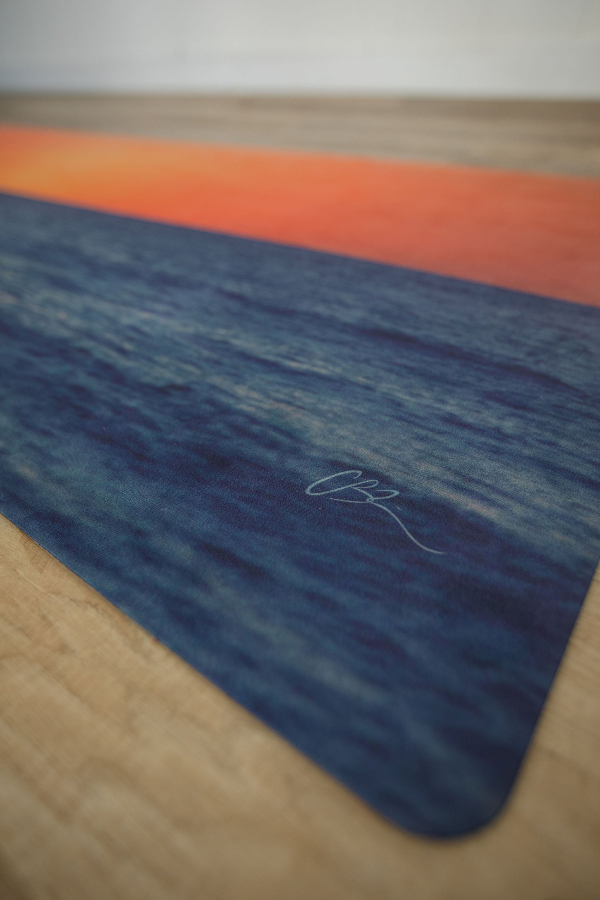 Yoga mat with a sunset design on a wooden floor