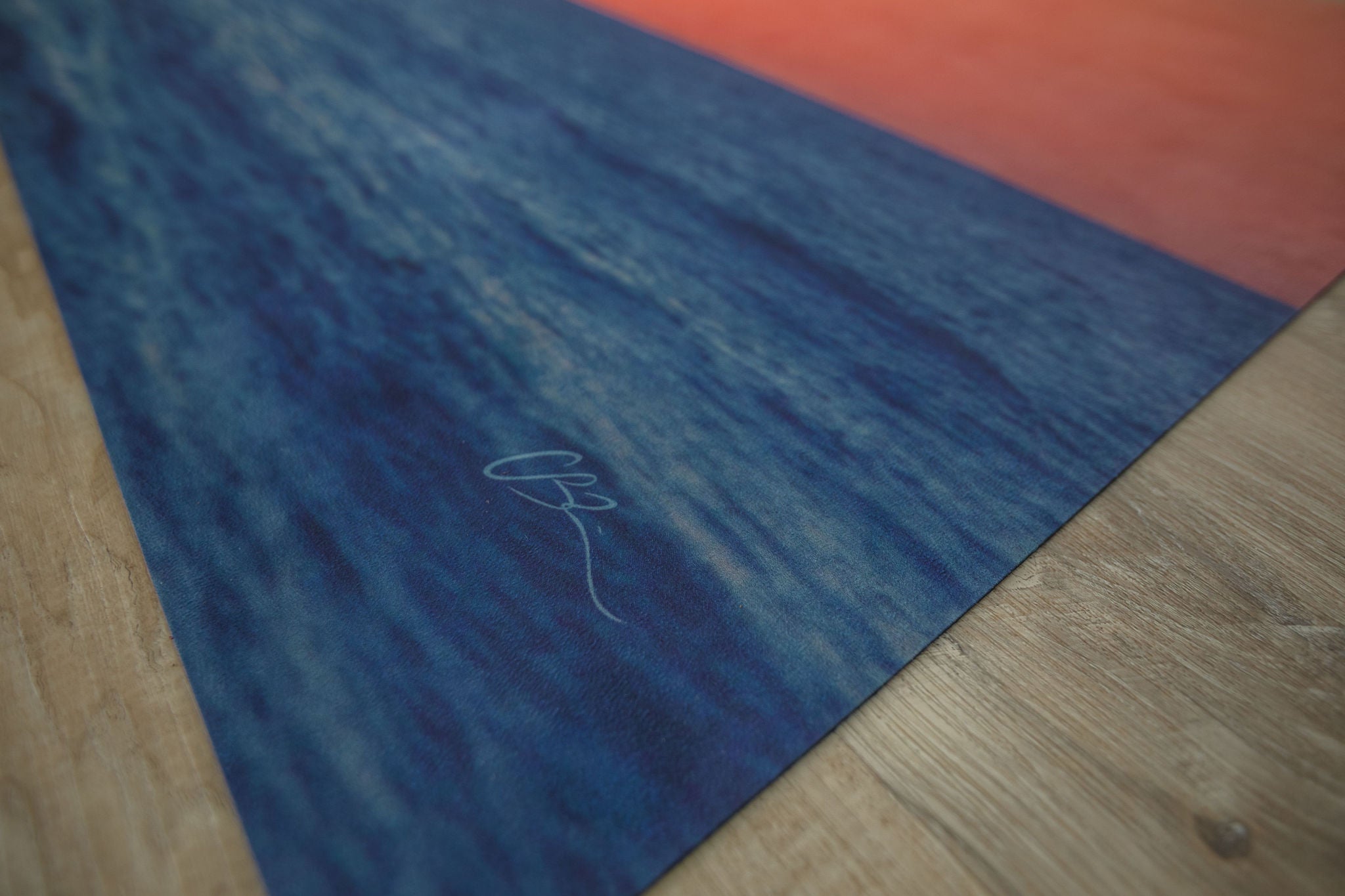 Yoga mat with a sunset design on a wooden floor