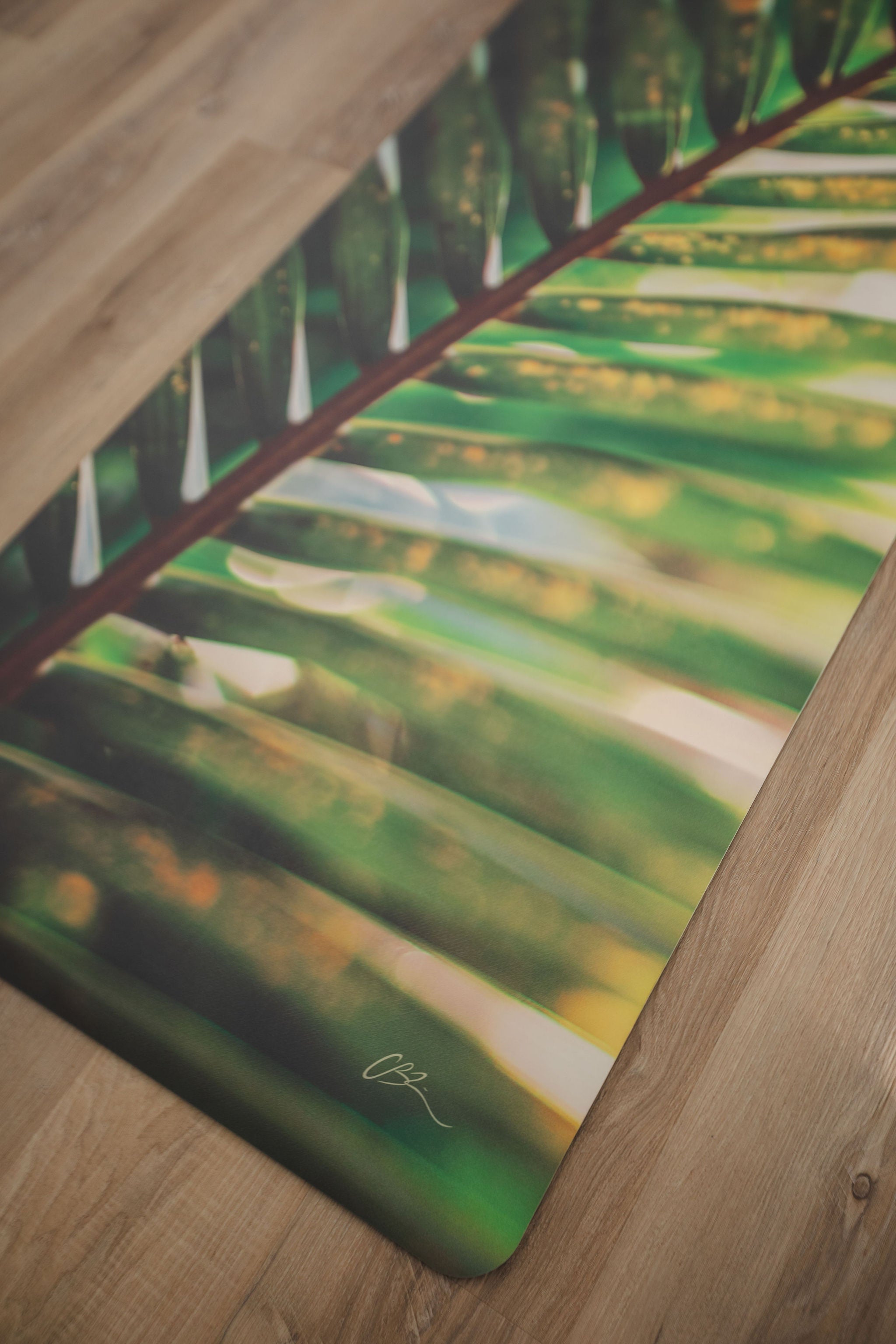 Yoga mat with a green leaf pattern on a wooden floor