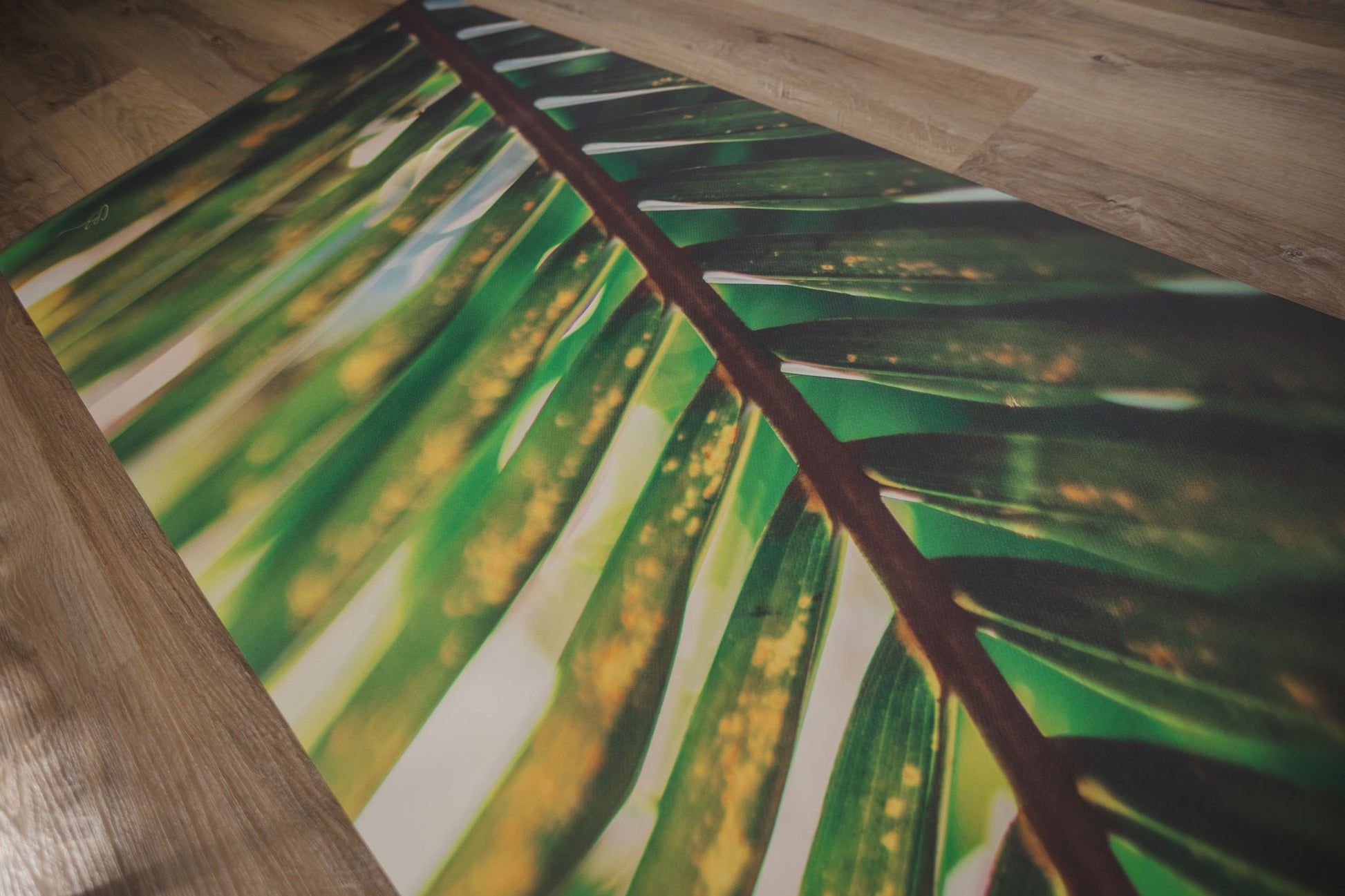 Close-up of a green leaf patterned rug on a wooden floor