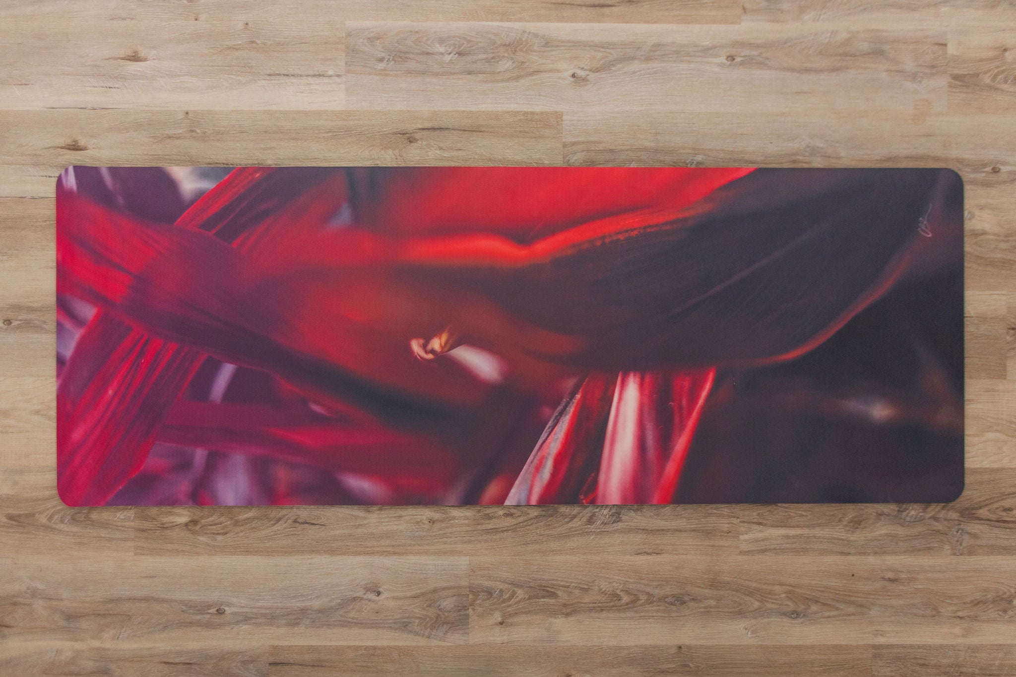Red and black abstract design yoga mat  on a wooden surface