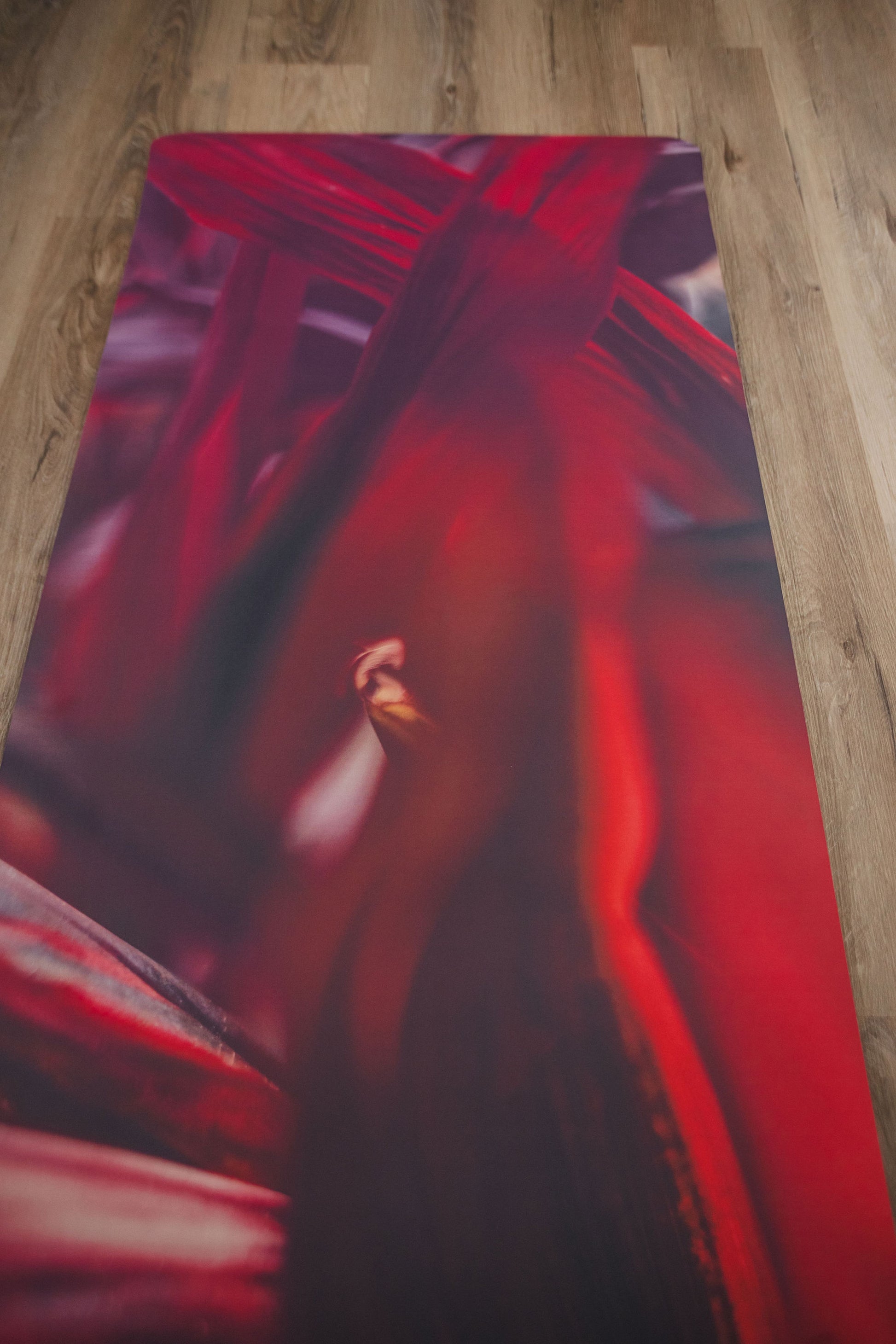 Red yoga mat with a design on a wooden floor