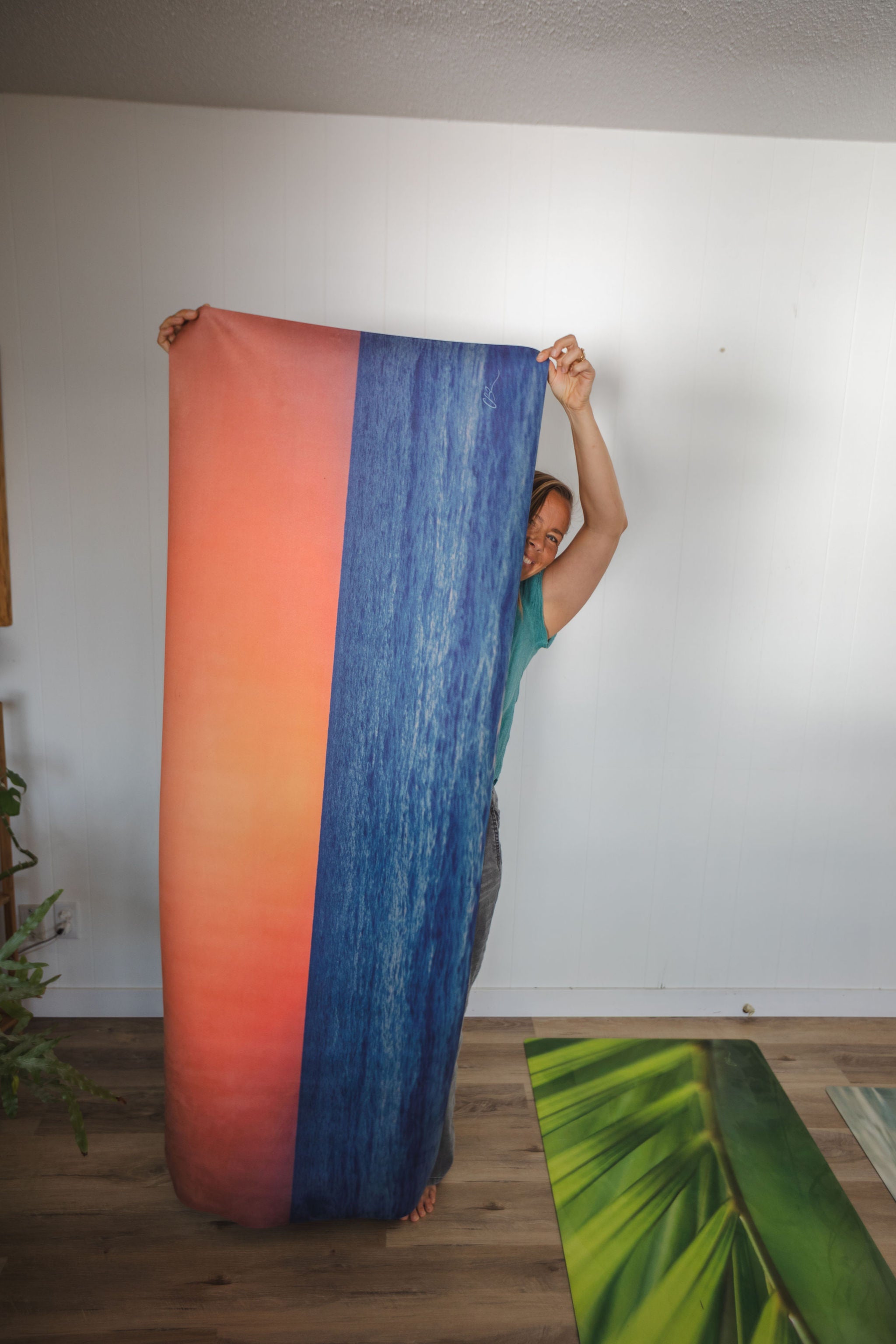 Yoga mat with a sunset design on a wooden floor