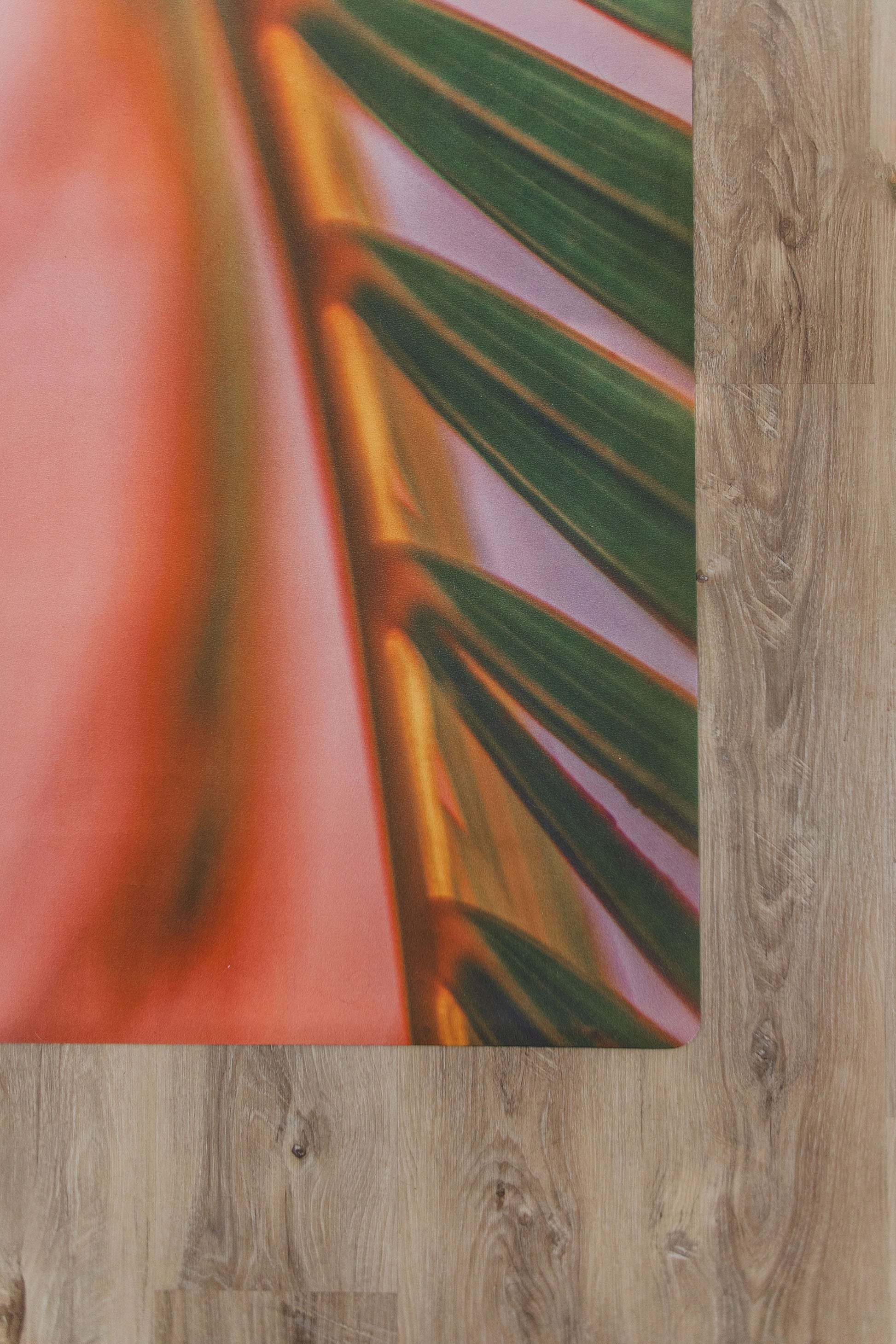 Pink and green yoga mat on a wooden floor