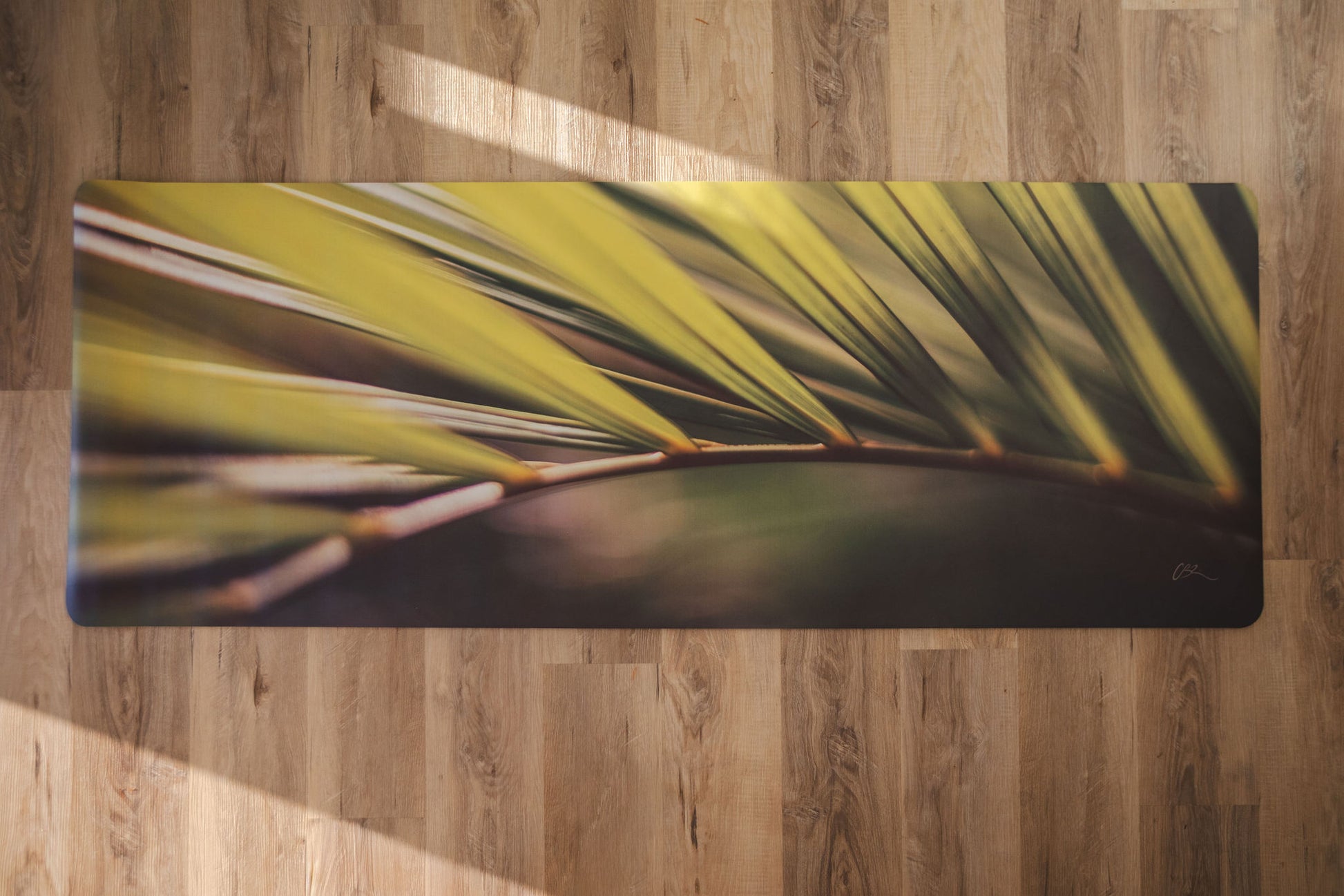 Yoga mat with leaf design on a wooden floor
