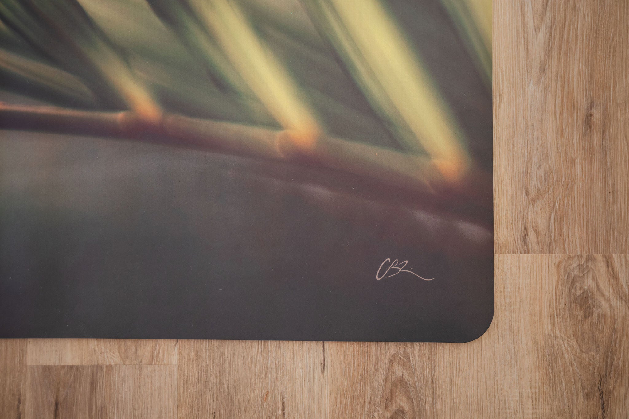 Yoga mat with a blurred natural design on a wooden floor
