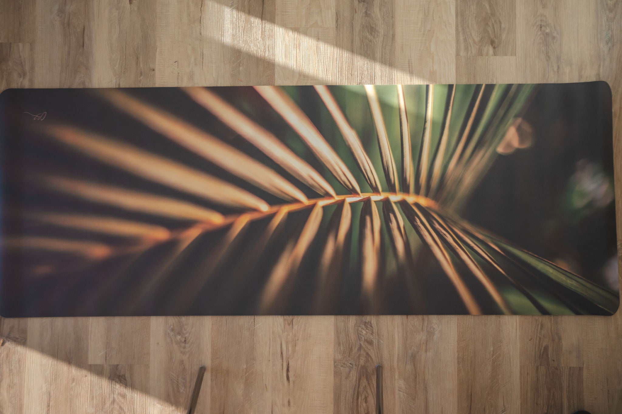 Yoga mat with palm leaf design on a wooden floor