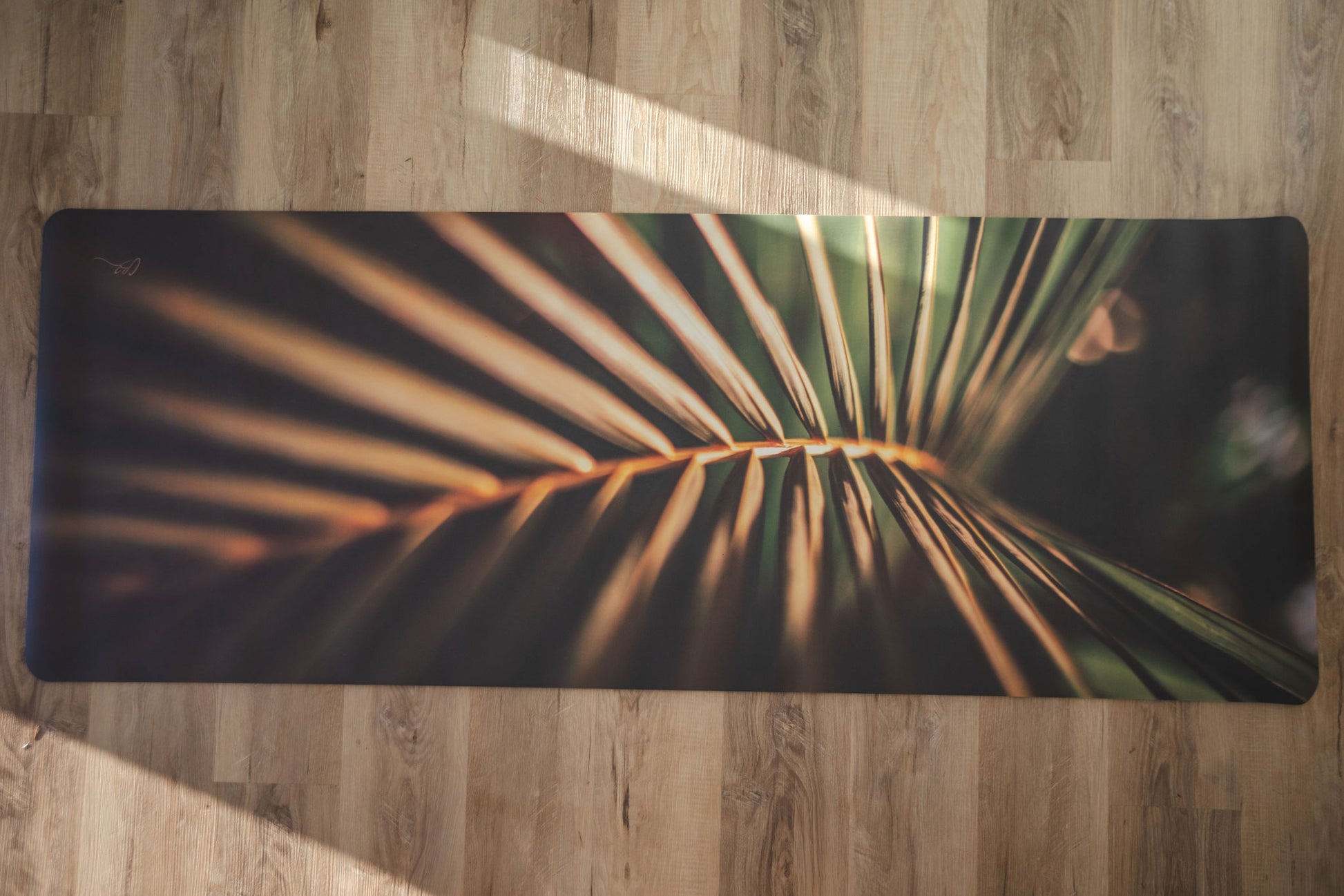 Yoga mat with palm leaf design on a wooden floor