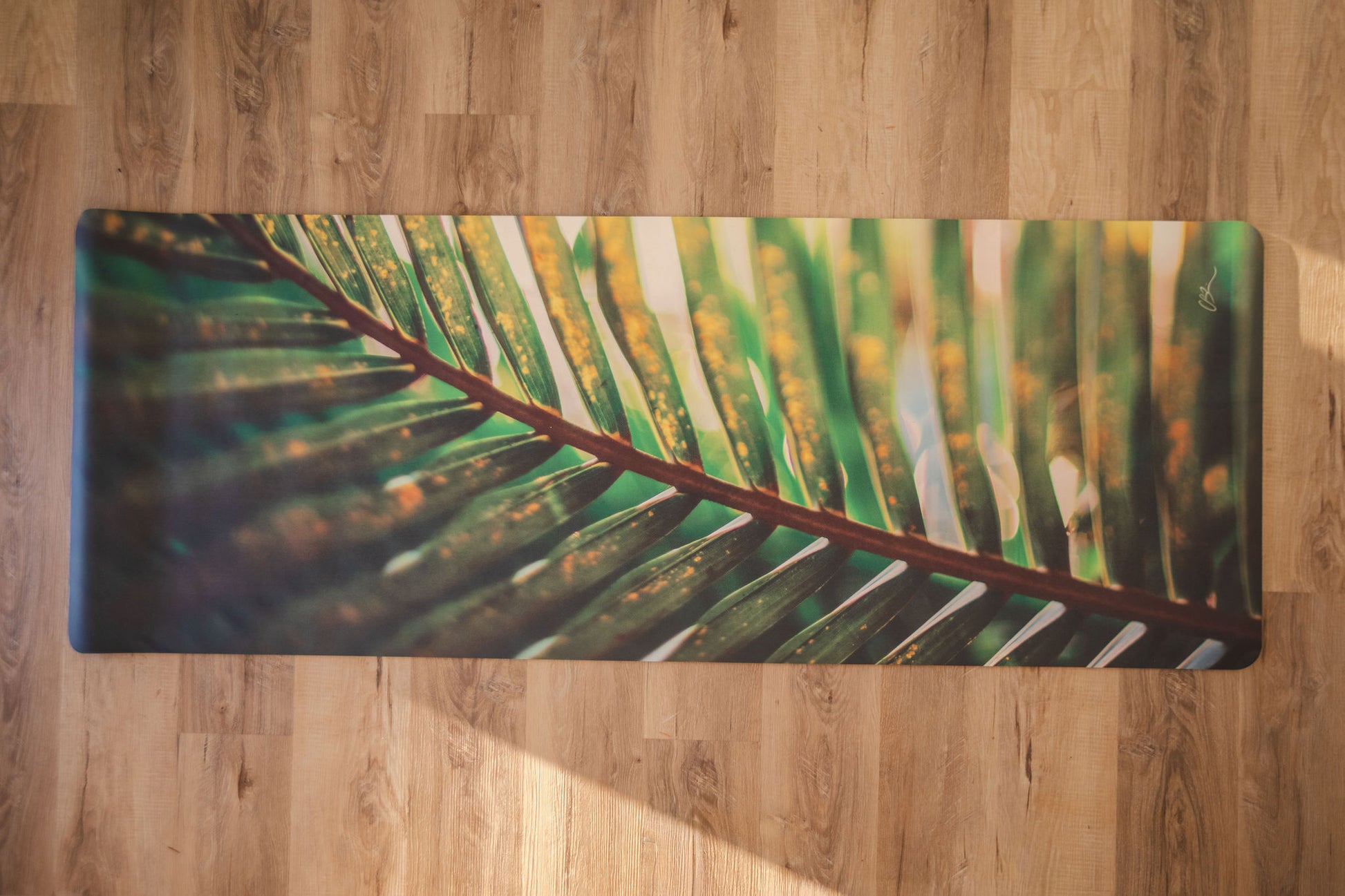 Yoga mat with a leaf design on a wooden floor
