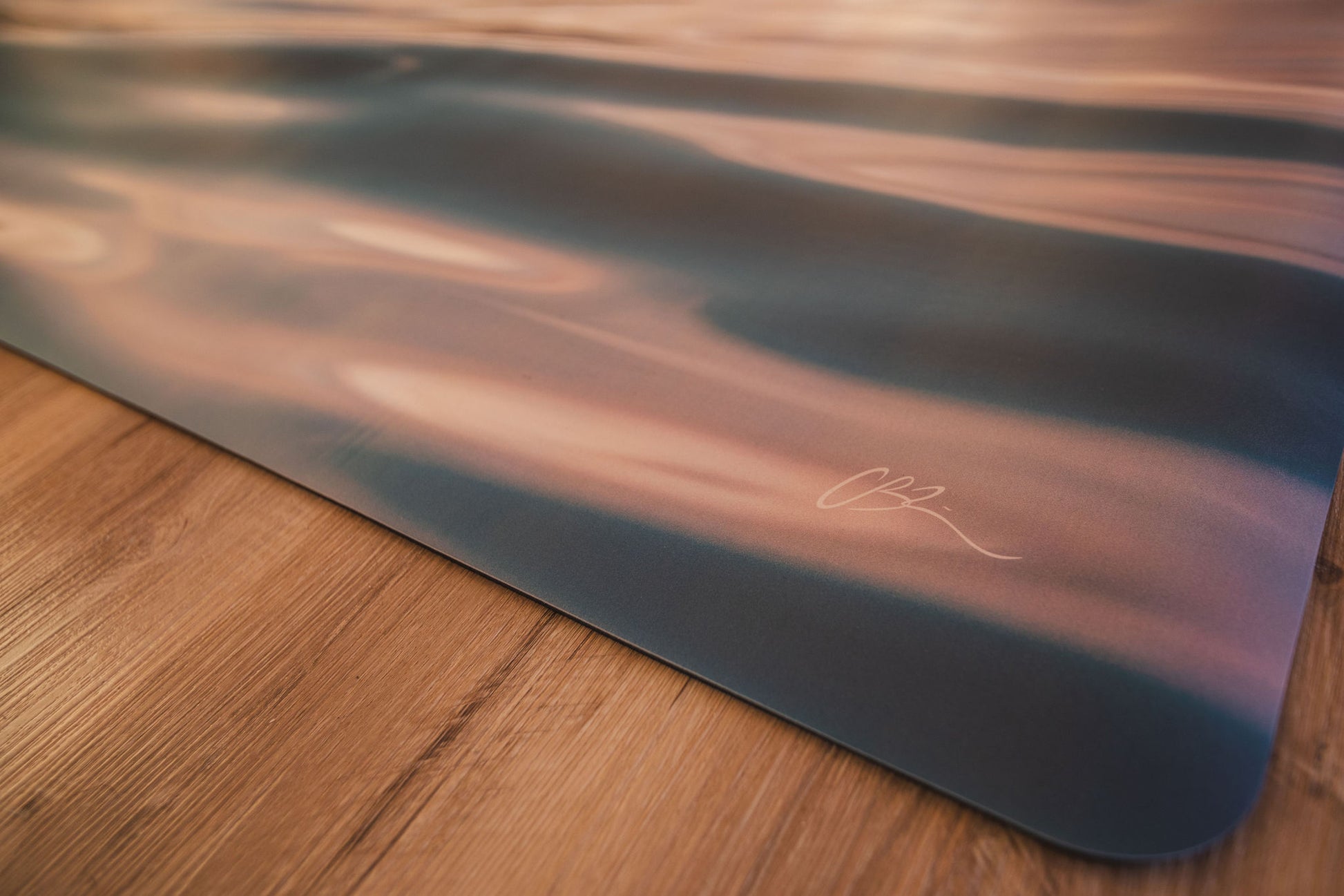 Yoga mat with a brand logo on a wooden floor