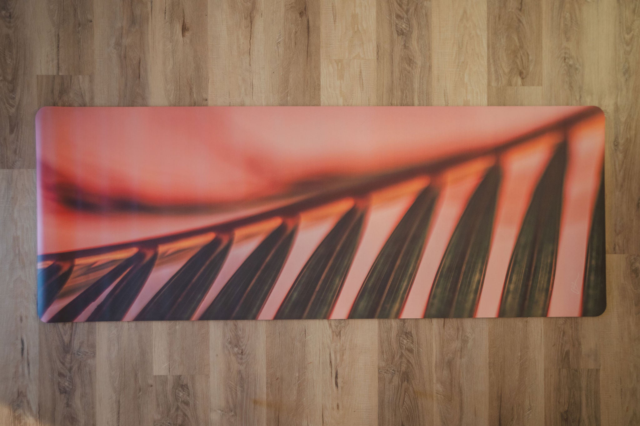 Yoga mat with leaf design on a wooden floor