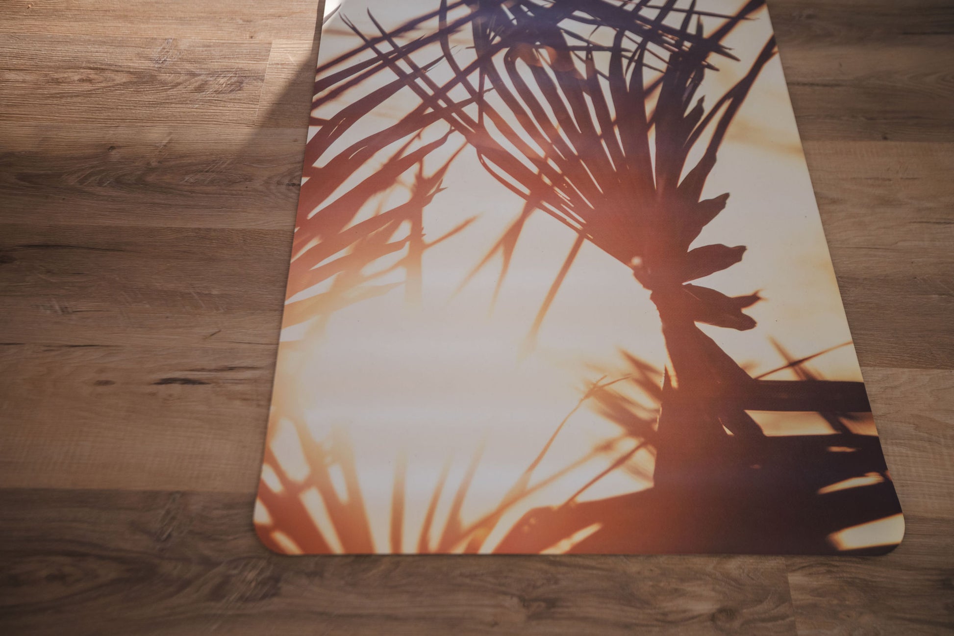 Yoga mat with palm tree design on a wooden floor