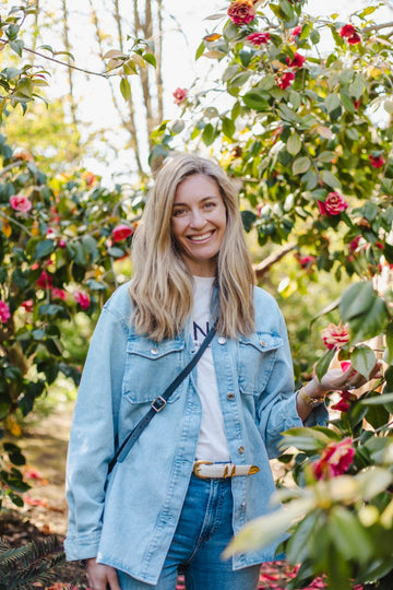 Woman standing among flowering trees in a garden